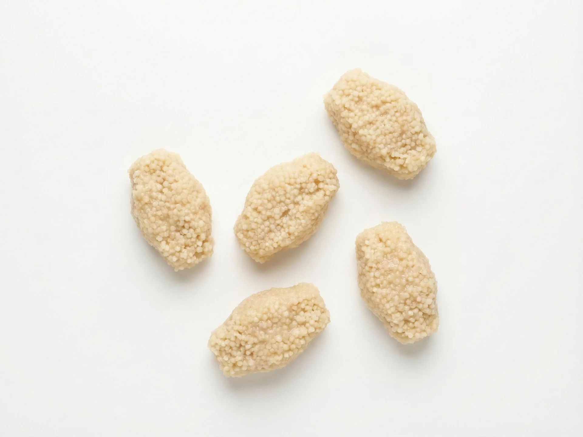 Para bebês de 6 a 9 meses, cozinhe o cuscuz até ficar bem macio e levemente pegajoso. Forme pequenas bolinhas ou aglomerados do tamanho de dois dedos adultos pressionados juntos. Esse formato ajuda os bebês a praticar a preensão palmar. Você pode misturar com leite materno, fórmula ou um purê fino para adicionar umidade e nutrientes.