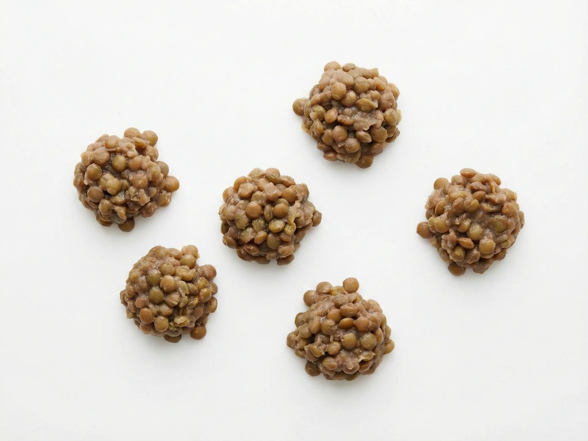 Für Babys von 9-12 Monaten servieren Sie gekochte Linsen als kleine, weiche Klümpchen oder gemischt in Gerichten wie Suppen und Eintöpfen. Sie können sie auch als Fingerfood in Form von Linsenpatties oder -bällchen anbieten, wobei sie feucht sein und sich im Mund leicht zerfallen sollten.