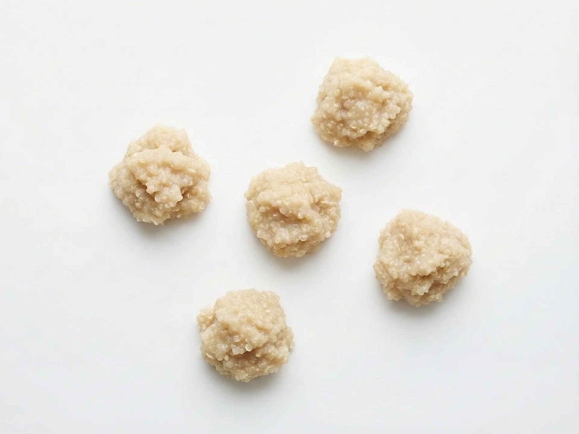 For babies 6-9 months, cook quinoa until very soft and slightly mushy, using extra water or broth to achieve a porridge-like consistency. Mix it with breast milk, formula, or a puree like sweet potato or apple to form a sticky, scoopable paste that's easy for little hands to grasp. Serve in small clumps on a highchair tray or loaded onto a pre-loaded spoon.