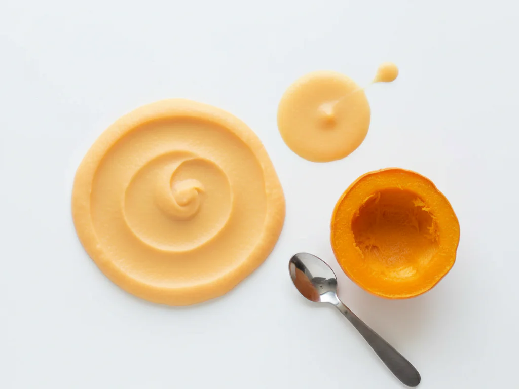 Pour les bébés qui débutent les solides, faites cuire la courge gemme jusqu'à ce qu'elle soit très tendre (à la vapeur ou à l'eau bouillante pendant 15-20 minutes), prélevez la chair et réduisez-la en purée bien lisse. Vous pouvez diluer la purée avec du lait maternel, du lait infantile ou de l'eau pour obtenir la consistance adaptée à votre bébé.
