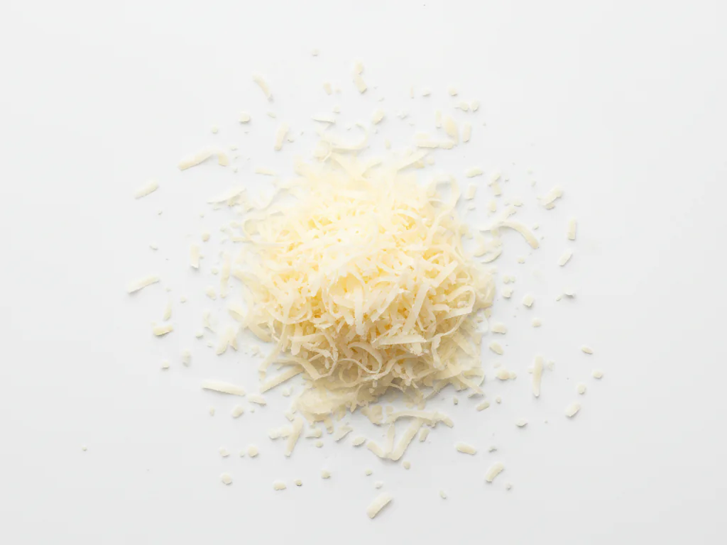 Snijd Parmezaanse kaas in kleine, dunne stukjes met een kaasrasp. Je kunt het over zachtgekookte groenten, pasta of roerei strooien. De stukjes mogen niet groter zijn dan een rijstkorrel.